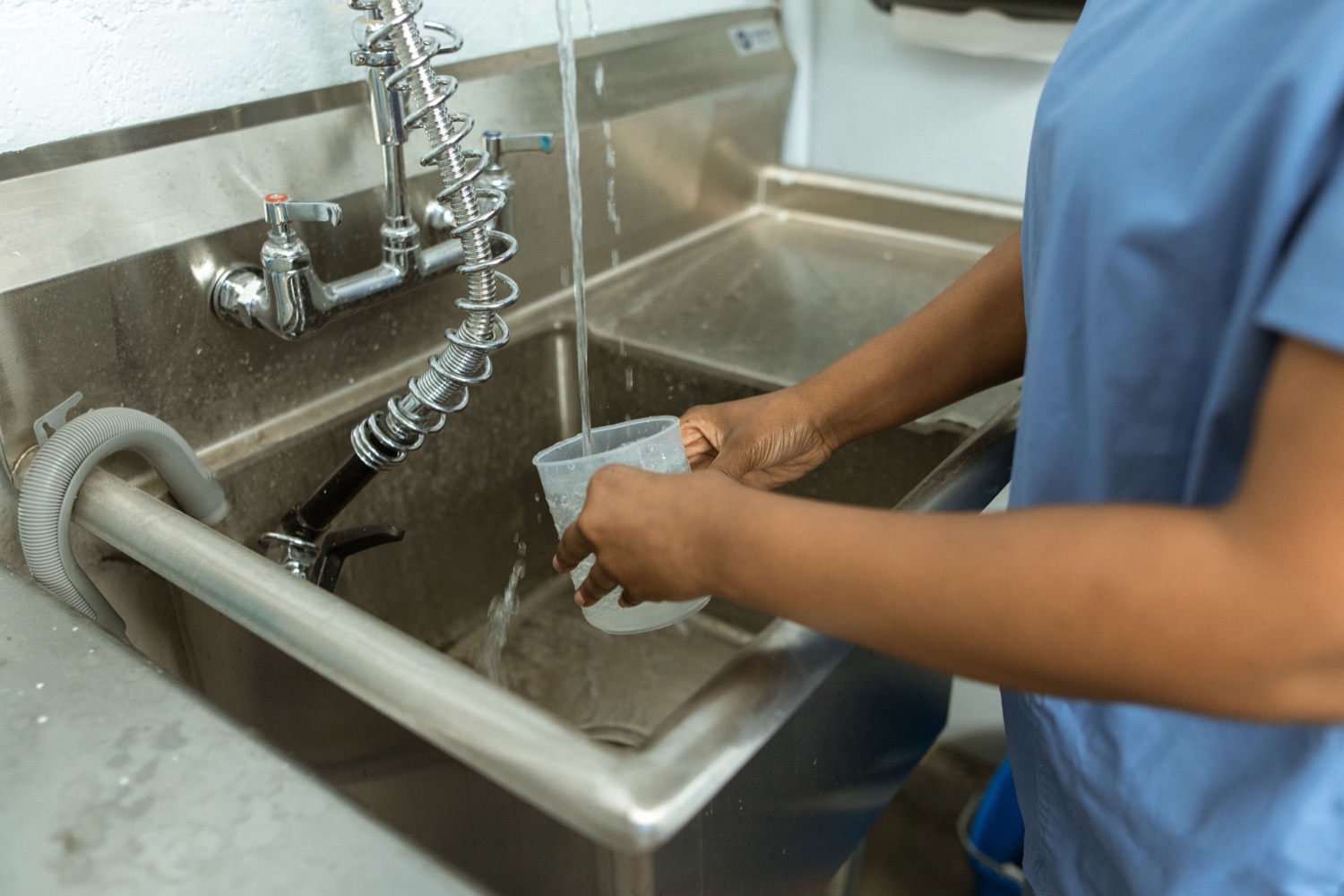 Water sample being taken at a tap in a hospital